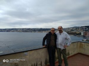 Два капитана, черный и белый, на фоне Неаполя и твердиземного моря.