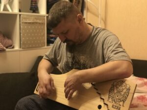 Григорий Николаевич Базлов играет на гуслях.