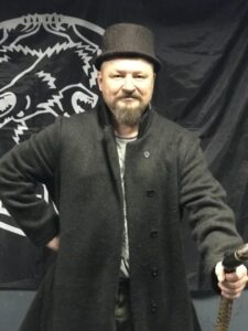 Григорий Николаевич Базлов с тросткой в традиционной русской одежде.