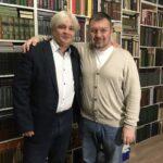 Вадим Грачев с Сергеем Зыковым на фоне библиотеки.