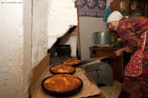 Бабушка печет пироги в печке Бабушка печет пироги в печке