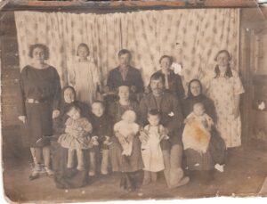 Фотография Богдановых Ивана и Александры на заднем плане среди родственников. Фотография Богдановых Ивана и Александры на заднем плане среди родственников. На фотографии слева от Ивана стоит его младшая сестра Анна, а в первом ряду справа с ребенком на руках сидит его мама Александра.